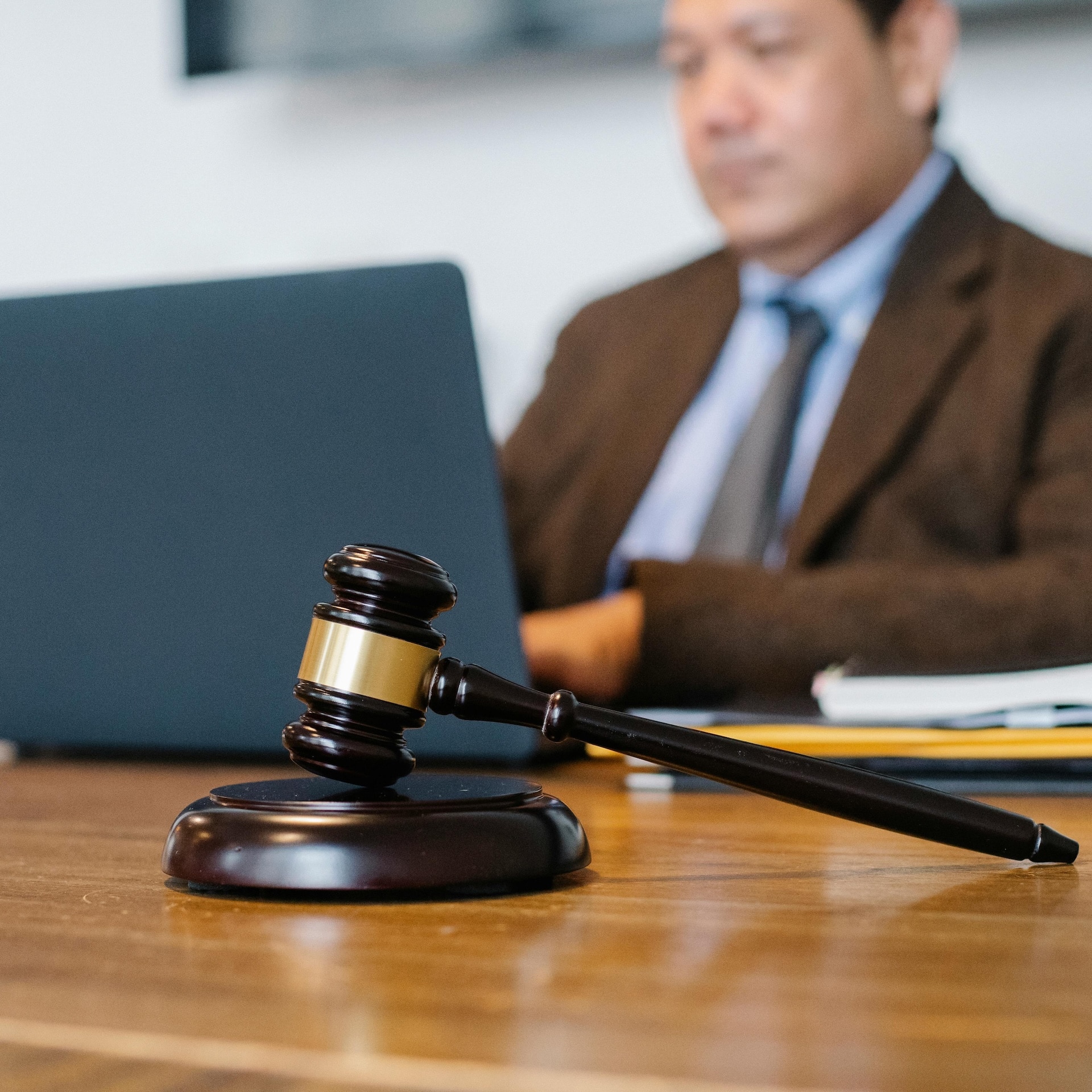 Judge's gavel on a legal desk with a lawyer working in the background, representing legal procedures how to get a restraining order.